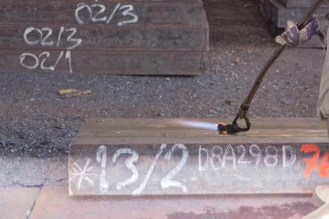 Worker are peeling the slab surface, Steel industry background. Stock Photos