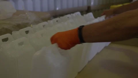 Worker Arranging Empty Plastic Coolant Containers in Factory 库存影片 335981072
