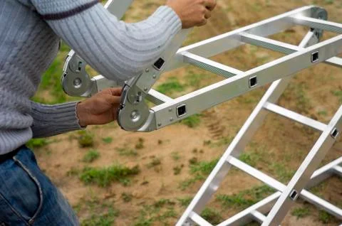 Worker arranging expandable ladder Stockfoto's