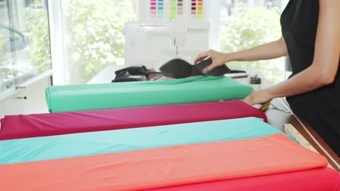 Worker is arranging rolls of a fabrics in a textile store. Stock Footage 139625219