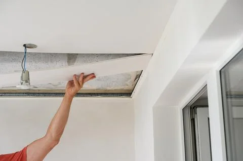 Worker assemble a suspended ceiling. Stock Photos