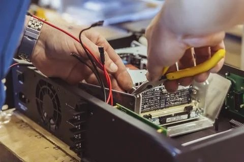 The worker assembles the amplifier to the speaker system Stock Photos