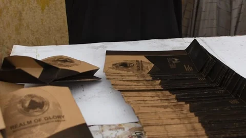 A worker assembles and folds branded paper packaging 動画素材 326936315