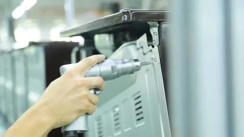 Worker assembles a gas stove on a factory conveyor Stock Footage 162902960