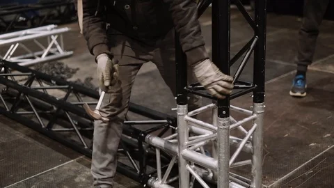 A worker assembles a metal structure on stage Video stock 124121684