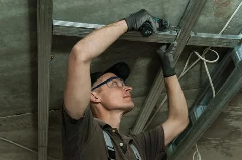 Worker assembles profile metal frame Stock Photos