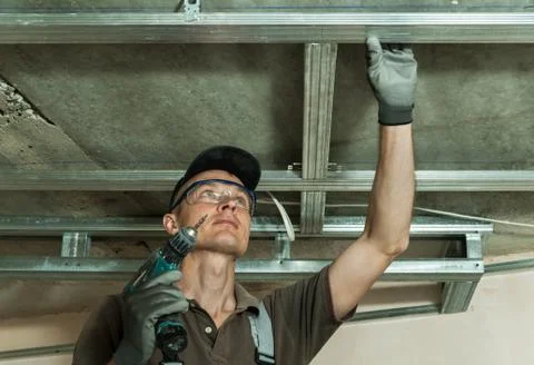 Worker assembles profile metal frame Stock Photos