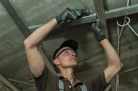 Worker assembles profile metal frame Stock Photos