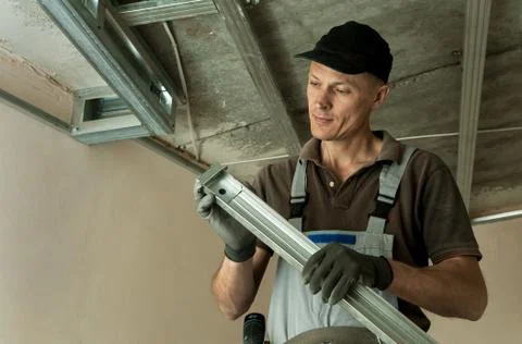 Worker assembles profile metal frame Stock Photos