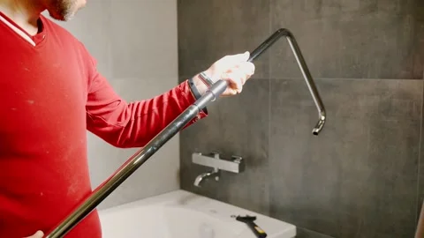 A worker assembles a shower rack in the bathroom. Installing a shower faucet. Stock-Footage 142774603