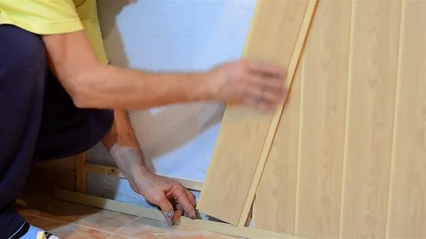 Worker assembles wood-paneled walls of the kitchen Stock Footage 78220406