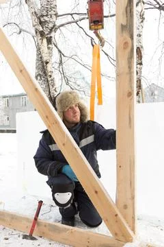 Worker assembling the frame of a wooden slide Fotos Stock