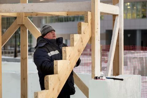 Worker assembling the frame of a wooden slide 스톡 사진