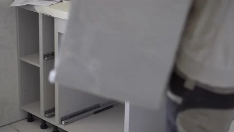 The worker assembling the kitchen takes out another module. Stock Footage 157288504