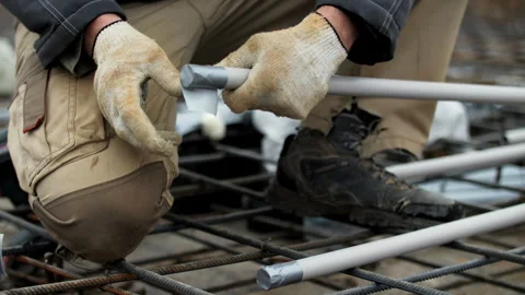 Worker Assembling Pipe Framework on Construction Site Stock Footage 297497911