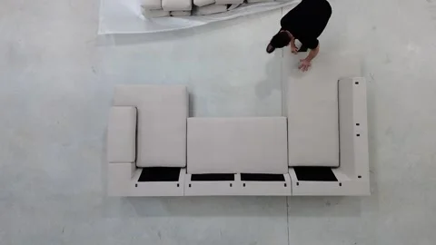 Worker assembling sofa, placing cushions and fluffing them Stock-Footage 300192344