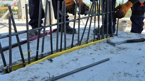 Worker assembling steel rebar and reinforcement bars between precast walls Stock-Footage 335298783