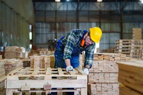 Worker Assembling Wooden Pallet in Lumber Warehouse Stock Photos
