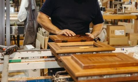 Worker assembling wooden shutter in carpentry workshop Stock Photos