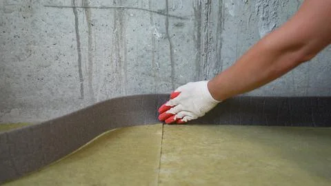 Worker attach Damper Tape To Wall. Sticking damper tape in the room for further Stock Photos