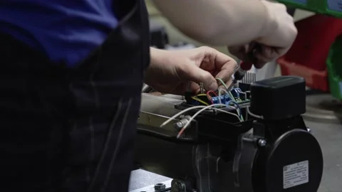 The worker attaches electrical circuits and blocks to the manufactured product. Stock Footage 213717664