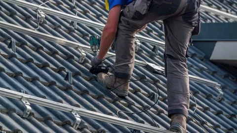 Worker Attaches Wire Box to Solar Panel Railing Mounts on Roof Stock Footage 150195769