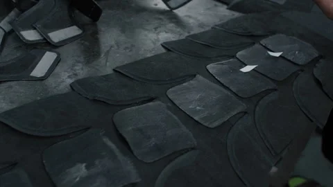 Worker Attaching Adhesive Strips to Shoe Parts on Factory Worktable in Stock Footage 341666958
