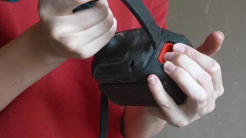 Worker attaching battery to cordless drill power tool Stock Footage 327158126