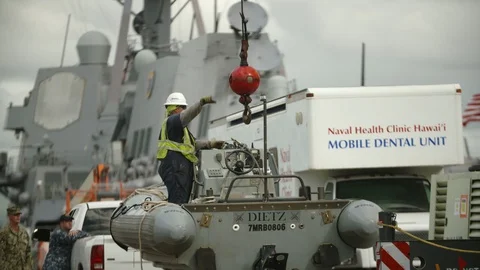 A worker attaching hook to a small ship Stock Footage 117732999
