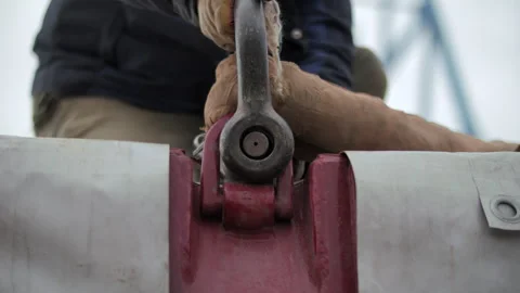Worker attaching lifting shackle to cargo hook Stock Footage 310748952