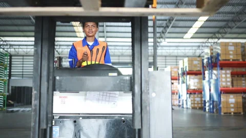 Worker in auto parts warehouse use a forklift to work to bring the box Stock Footage 255275987