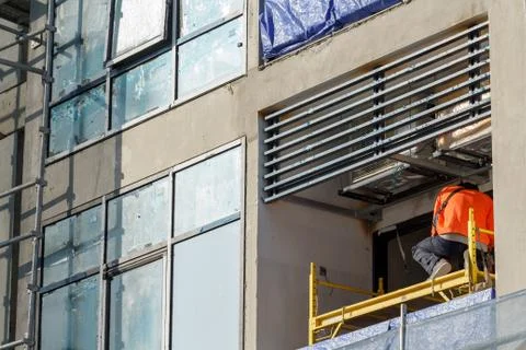 Worker on balcony of under construction high rise condominium Stock Photos