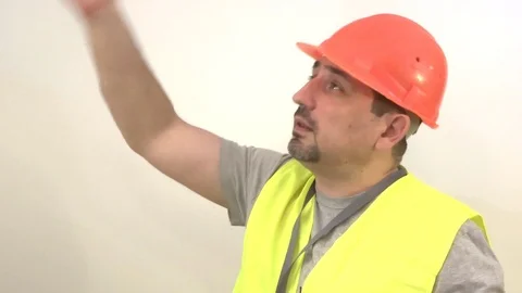 Worker with a beard and in a helmet giving a signal Stock Footage 93132862