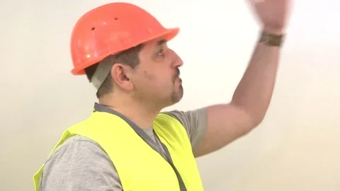Worker with a beard and in a helmet giving a signal Stock Footage 93132904