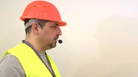 Worker with a beard and in a helmet giving a signal Stock Footage 93305801