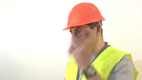 Worker with a beard and in a helmet speaks on the phone Stock Footage 93304207