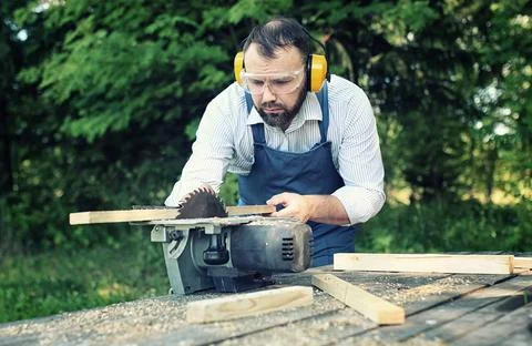 Worker beard man with circular saw desktop items, and the process of prepa... Stock Photos