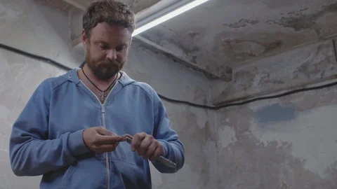 Worker with a beard in the workshop sharpens a pencil with an office knife. 4k Stock Footage 116782654