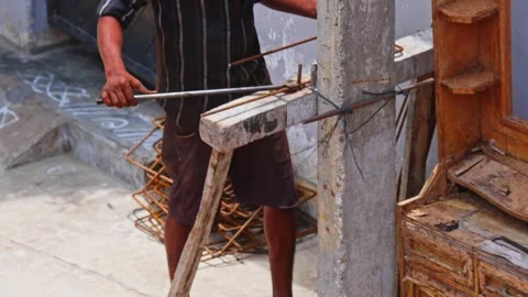 Worker bending a 8mm rebar to rectangle shape for column work at construction Stock Footage 325838304