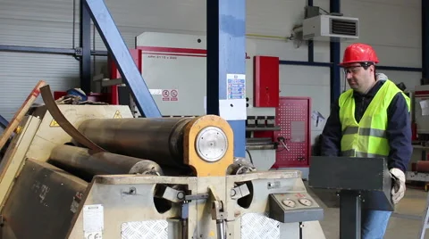 Worker bending metal on hydraulic machine with three rollers Stock Footage 67102783