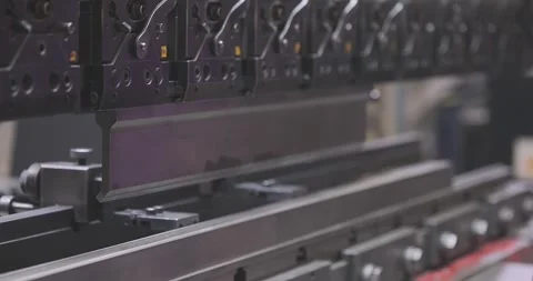 A worker bends a metal part in a machine. Hydraulic sheet metal bending machine Stock Footage 273284191
