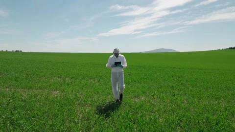 A worker, a biologist in a protective suit with a mask on his face, walks thr Stock Footage 157577866