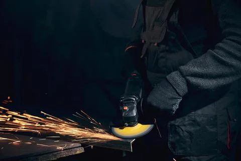 Worker in black gloves working angle grinder with metal. Stock Photos