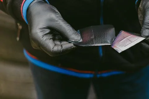 Worker with black rubber gloves in a workshop opening radial tire patch Stock Photos