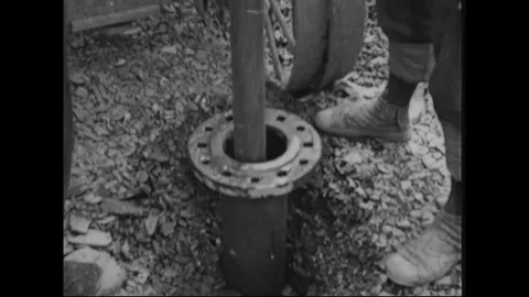 Worker blasts surface with explosives and shovel load ores into cart - 1942-1945 動画素材 99782667