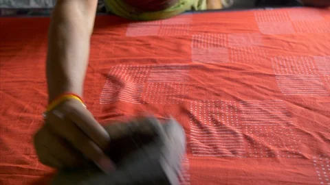 A worker block printing red fabric with the white design 動画素材 117469117