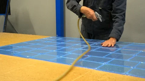 Worker blowing dust from plastic at the factory Stock Footage 119398262