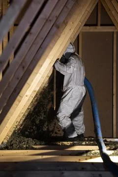 Worker Blows Cellulose Insulation Into Steep Triangular Attic Fotos Stock