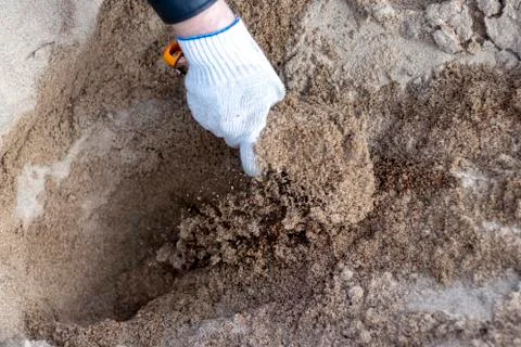 Worker in the blue boilersuit and work gloves with shovel is on the construct Stock Photos