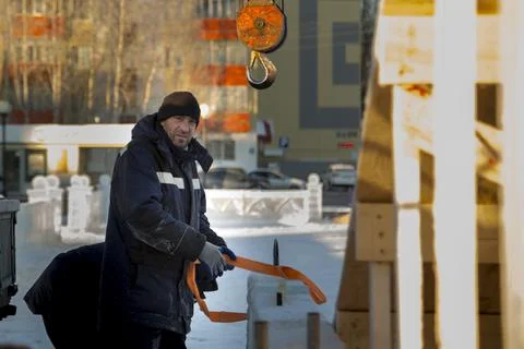 Worker in blue jacket unloading ice panels 스톡 사진